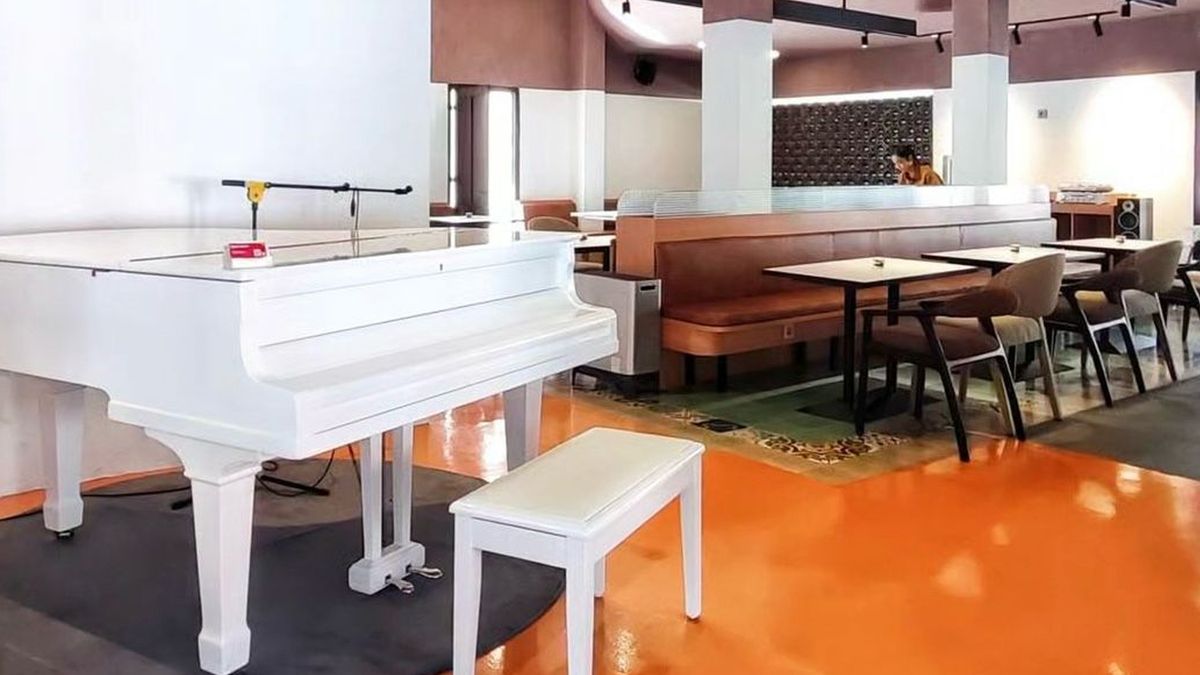 White grand piano in Penka 1967 listening bar at night, warm amber lighting
